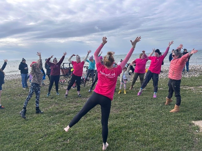 A group of people stretching while taking part in fundraising for Women's Aid.