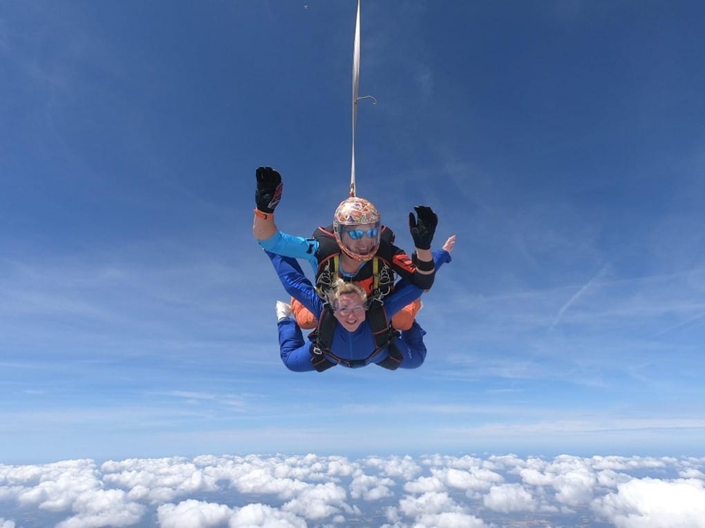 A woman and a man sky diving.