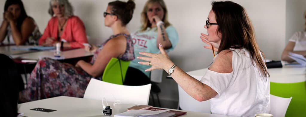 A group of women chatting around desks