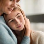 Mother hugging daughter