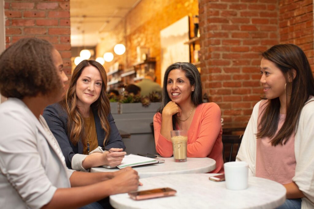 Group of women sitting around tables in a café