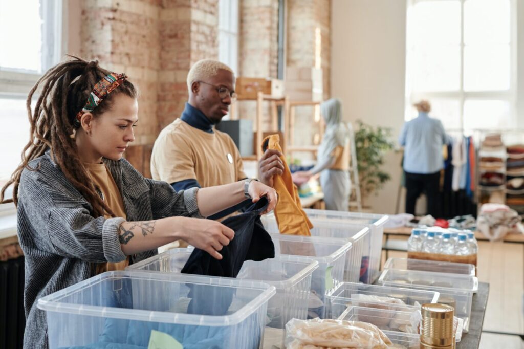People looking through boxes of clothes