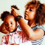 Woman doing child's hair