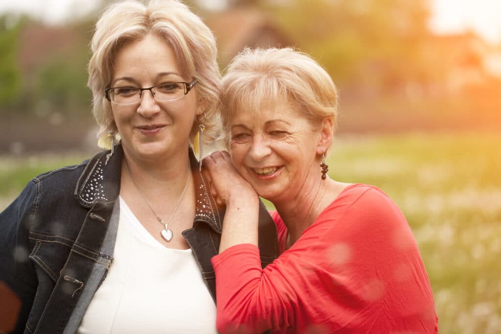 Two women standing close together and smiling