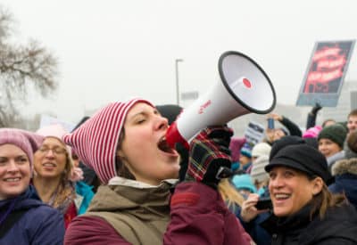Woman speaking through a megaphone in a crowd of people