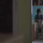 Boy sitting in room with door ajar