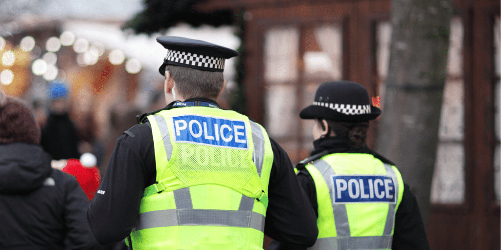 Two police officers facing a crowd